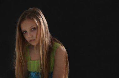 Siyah arka planda üzgün bir kızın portresi.