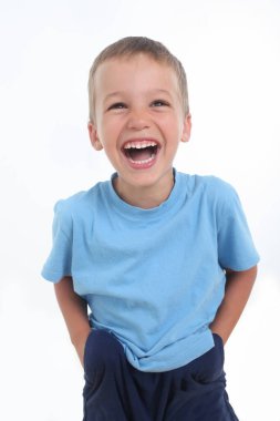 Mavi tişörtlü, gülümseyen küçük çocuğun portresi.