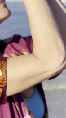 Mutlu olgun bir kadın ellerini havaya kaldırıyor ve kollarını gökyüzüne açıyor.