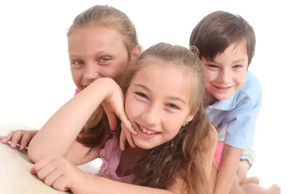 Beyaz arka planda üç neşeli çocuğun portresi