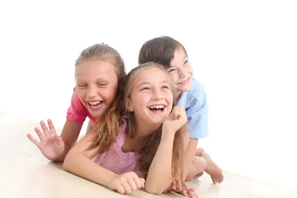 Beyaz arka planda üç neşeli çocuğun portresi