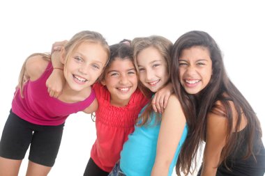 Bir grup neşeli kız beyaz arka planda sarılıp gülümsüyor.