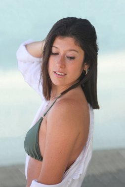 Bikinili ve beyaz tişörtlü güzel bir kadın.