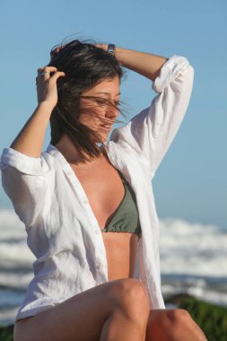 Bikinili ve beyaz tişörtlü güzel bir kadın.