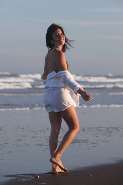 Kumsalda genç ve neşeli bir kadın Yazın tadını çıkarıyor 