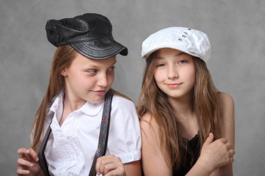 Gri arka planda iki havalı genç kız portresi