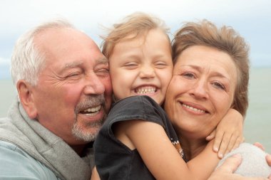 Dışarıda mutlu bir aile. Torunları ve büyükanneleri kucaklaşıp gülümsüyor.