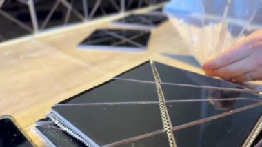 Kadın usta seramik fayansların el yapımı mozaiğini yapıştırıyor. Duvarı süslüyordum. Fayansları elleriyle yerleştiriyor ve fayansları yapıştırıyor..