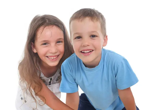 İki neşeli kardeşin portresi, beyaz arka plandaki küçük çocuk ve kız.