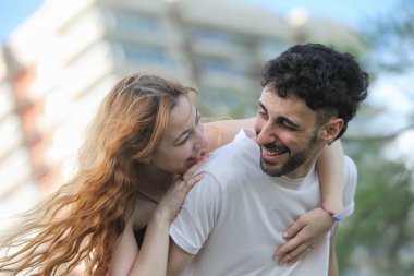 Genç, neşeli ırklar arası çift yaz günü parkta eğleniyor.