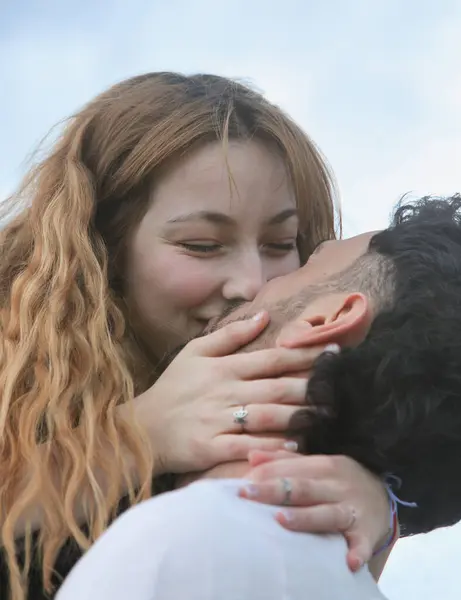 Birbirlerine aşık genç bir çift öpüşüyor.