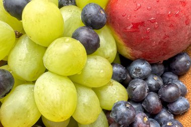 Taze meyve, yabanmersini, şeftali ve üzümleri bir kasede yakın plan çek. 