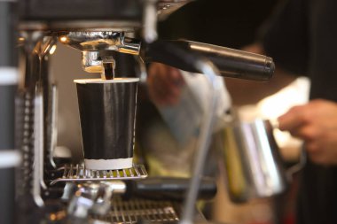 Kafede kahve yapan baristanın ellerine yakın çekim.