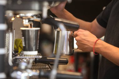 Kafede kahve yapan baristanın ellerine yakın çekim.