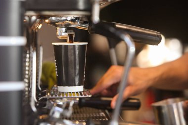 Kafede kahve yapan baristanın ellerine yakın çekim.