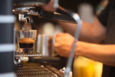 Kafede kahve yapan baristanın ellerine yakın çekim.