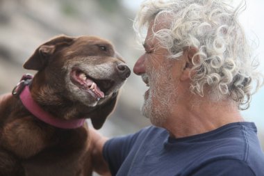 Neşeli son sınıf öğrencisinin dışarıda köpekle bağ kurmasının portresi.