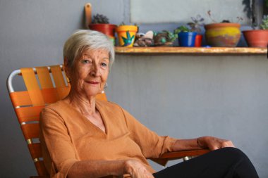 Neşeli son sınıf öğrencisi Latin kadın arka bahçesinde dinleniyor.  