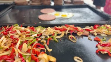 Sokak yemekleri, hamburgerler, sebzeler, sahanda yumurtalar, sosisler, açık hava pazarında.