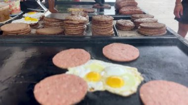 Sokak yemekleri, hamburgerler, sebzeler, sahanda yumurtalar, sosisler, açık hava pazarında.