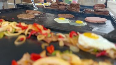 Sokak yemekleri, hamburgerler, sebzeler, sahanda yumurtalar, sosisler, açık hava pazarında.