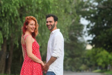 Yaz günü parkta birbirine aşık genç, neşeli, melez bir çiftin portresi.