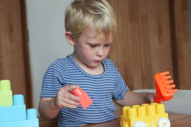  Evden bağımsız oyun ve çocukluk gelişiminde plastik yapı taşlarıyla oynayan küçük çocuk