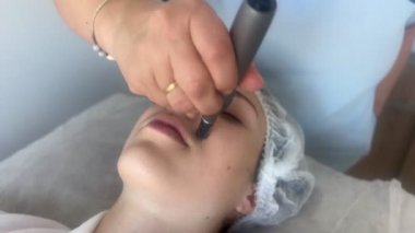 Kadının güzellik kliniğinde ya da kaplıcada profesyonel kozmetik uzmanı tarafından Derma Pen ile tedavi görmesi