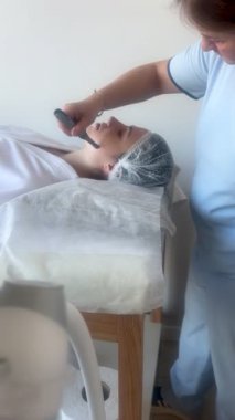 Kadının güzellik kliniğinde ya da kaplıcada profesyonel kozmetik uzmanı tarafından Derma Pen ile tedavi görmesi
