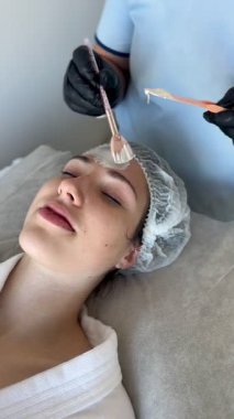 Güzellik kliniğinde ya da kaplıcada yüz bakımı sırasında genç kadınların yüzlerinin kapatılması, güzellik uzmanının yağ ya da maske sürmesi.