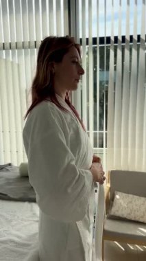  Kızıl saçlı, 30 'larında, masaj yatağında beyaz bir bornoz giymiş bir kadın. Düşünceli bir şekilde aynaya bakıyorum. Sakin, huzurlu, sağlıklı bir an..