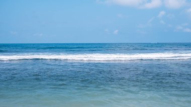 Kumsalda mavi deniz ve dalgalar güneşli bir günde