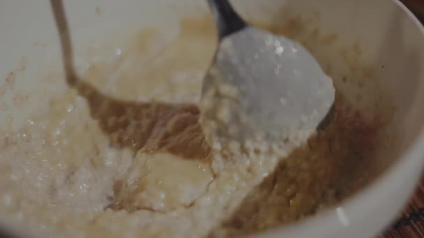 女人用勺子把牛奶 榛子和麦片混合在一个碗里 优质Fullhd影片 — 图库视频影像