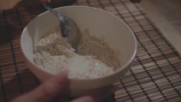 女人把牛奶和麦片早餐燕麦和勺子混合在一个碗里 优质Fullhd影片 — 图库视频影像