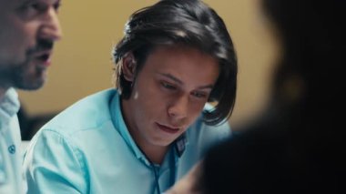 Gülümseyen genç bir erkek çalışan modern bir ofisteki bir meslektaşından destek ve övgü alıyor. Profesyonel bir ortamda olumlu iş ortamı, motivasyon ve takım teşvikleri.