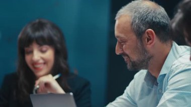 Ofis toplantısında proje detaylarına odaklanmış kıdemli bir çalışan. Modern bir iş ortamında yakın çekim. Tecrübe, liderlik ve kurumsal takım çalışması kavramı.