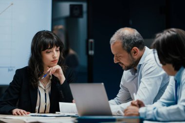 Beyaz meslektaşlar, bir ofis konferans odasında profesyonel bir iş toplantısı sırasında görüşlerini paylaşan birini dikkatle dinlerler. Sahne aktif dinleme ve kurumsal takım çalışmasında çarpışma gösteriyor.