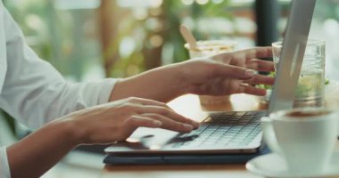 Kafkasyalı genç bir kadının dizüstü bilgisayarla yazı yazarken yakın plan videosu. Sonra da ofis kafeteryasındaki işine yoğunlaşırken bardaktan su içerken yüzüne çarpıyor..