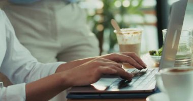 Yavaş çekim videosu, kadının elleri dizüstü bilgisayarda yazarken, garsonun su bardağını değiştirmek için yaklaştığında yüzüne dönmesiyle başlıyor. Sahne çalışanların konsantre ifadelerine odaklanmış olarak sona eriyor..