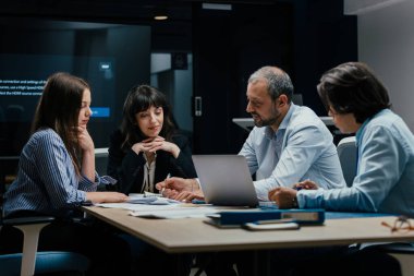 Kafkasyalı gevşek yöneticiler ve resmi giyinmiş ortaklar modern yapay ofisteki büyük ekranda ilerleme raporunu tartışıyorlar, işbirlikçi iş beyin fırtınası oturumu