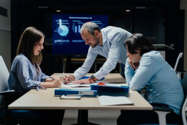 Modern ofiste kıdemli Kafkas yöneticisinin rehberlik ettiği şirket danışmanlığı sahnesi, ekranda ilerleme, profesyonel gelişim ve kurumsal kültür eğitimi konularında tartışmalar