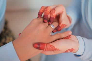 Gelin, damada nikah yüzüğünü resmi tören sırasında takmış. Aile ve mutluluk kavramı