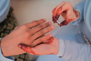 Gelin, damada tören sırasında bilezik takmış. Aile ve mutluluk kavramı