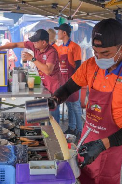 Kuantan, Malezya - FEBRUARI 2ND, 2023: KUANTAN 'da yol kenarındaki tezgahlardan helal gıda satan Müslüman erkek satıcılar