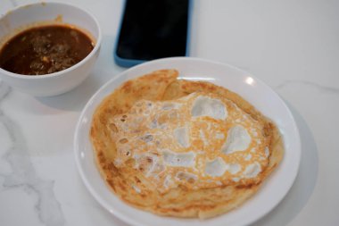 Bir tabak roti tampal, roti canai veya Malezya Prata ekmeği..