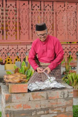 Kurban Bayramı 'nı kutlamak için ızgarada balık pişirip ızgara yapan Müslüman bir aile..