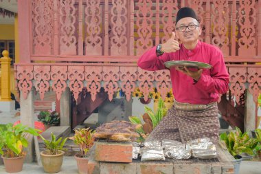Kurban Bayramı 'nı kutlamak için ızgarada balık pişirip ızgara yapan Müslüman bir aile..