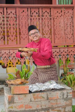 Kurban Bayramı 'nı kutlamak için ızgarada balık pişirip ızgara yapan Müslüman bir aile..
