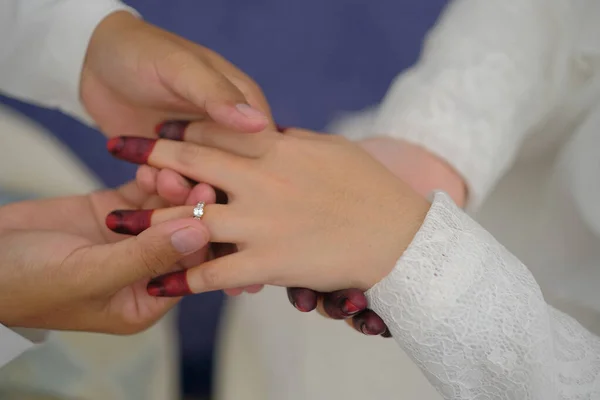 Malay wedding bride bolstering ring on groom\'s finger. Bride wear wedding rings to left finger of groom, Muslim wedding, Wedding Poster, Close up hand
