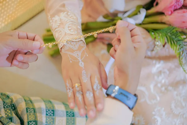 在马来西亚举行的马来婚礼上 新郎正在把手镯戴在新娘的手上 新娘的手与指甲花 — 图库照片